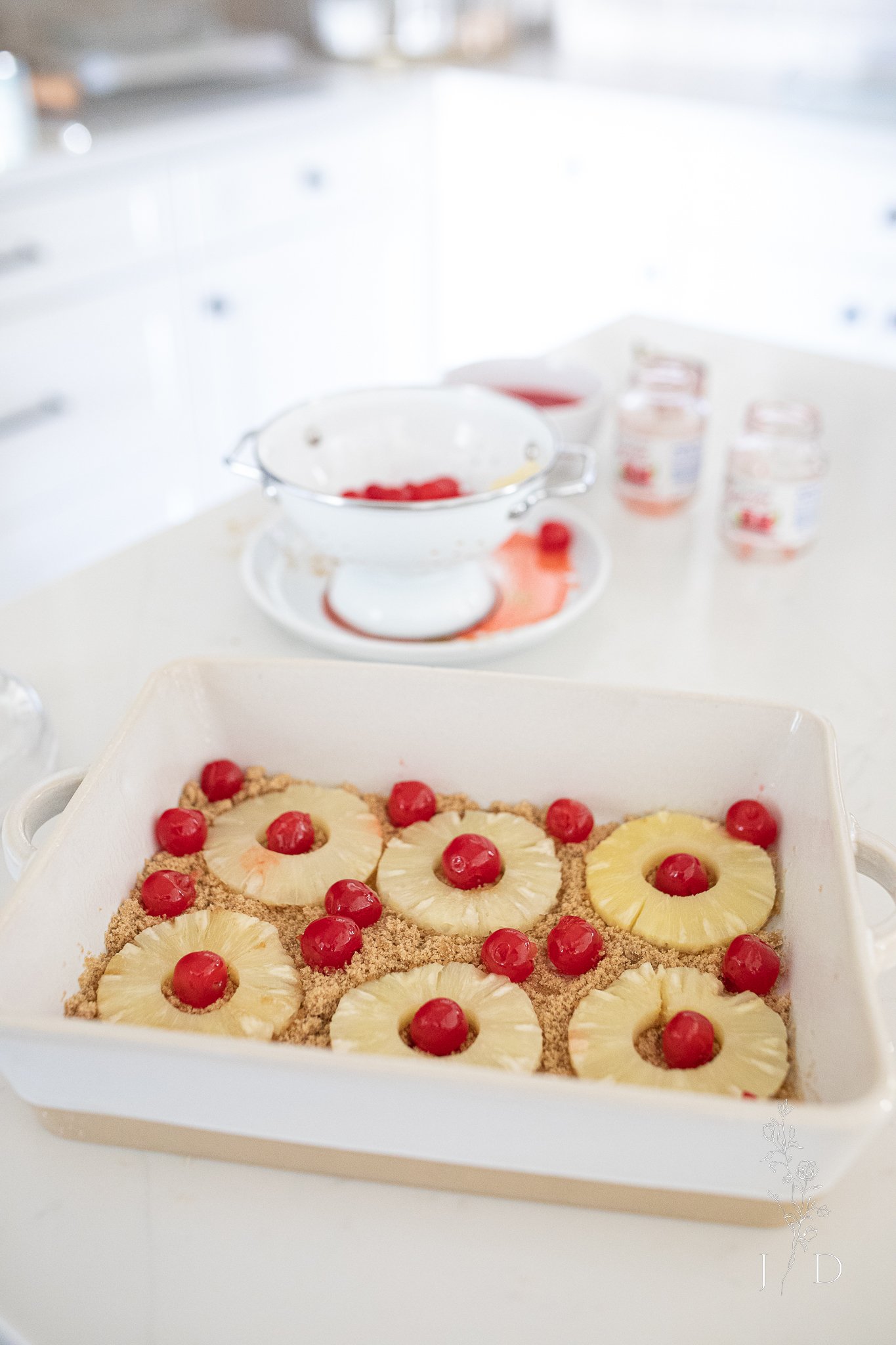 Pineapple, cherries, and brown sugar at the bottom of a dish. 