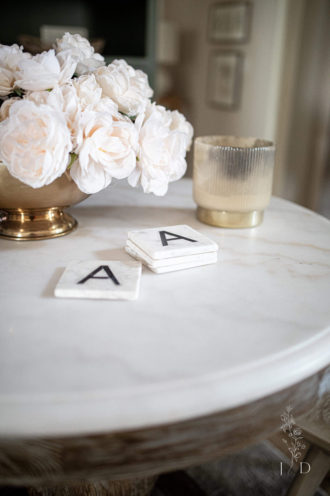 Warm white faux roses on a marble table from Arhaus