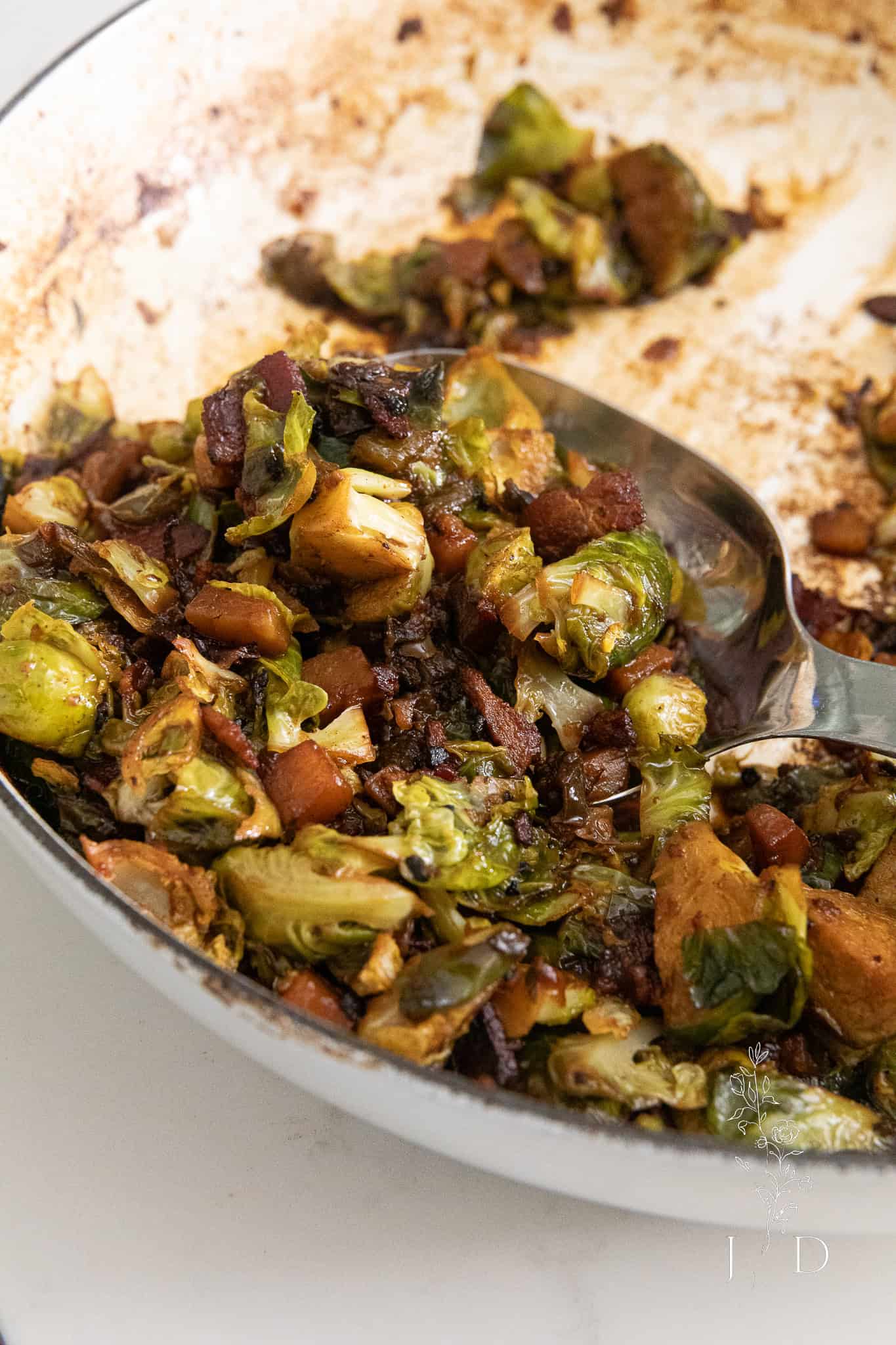 Cooked Brussels sprouts with crispy bacon bits in a spoon