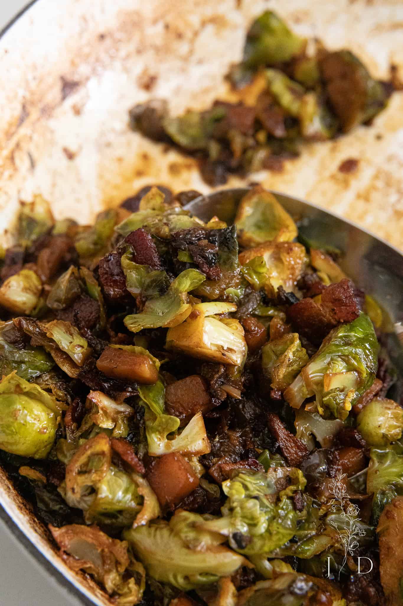 Golden brown Brussels sprouts tossed with caramelized onions and bacon pieces